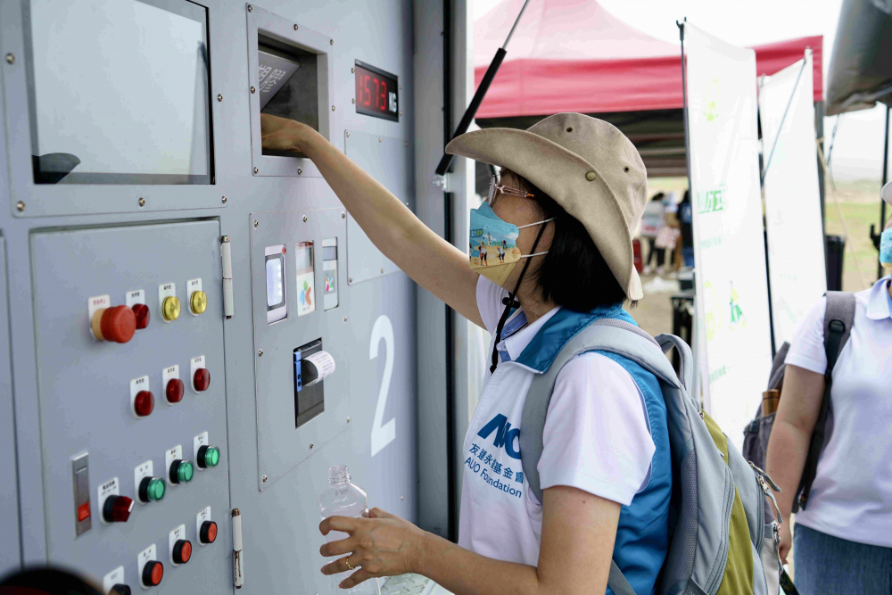 志工們將拾起的寶特瓶投入「好歸塑專車」，讓廢棄塑料空瓶可以直接粉碎、縮小體積，未來將可再製成購物袋、寶特衣、悠遊卡等生活用品